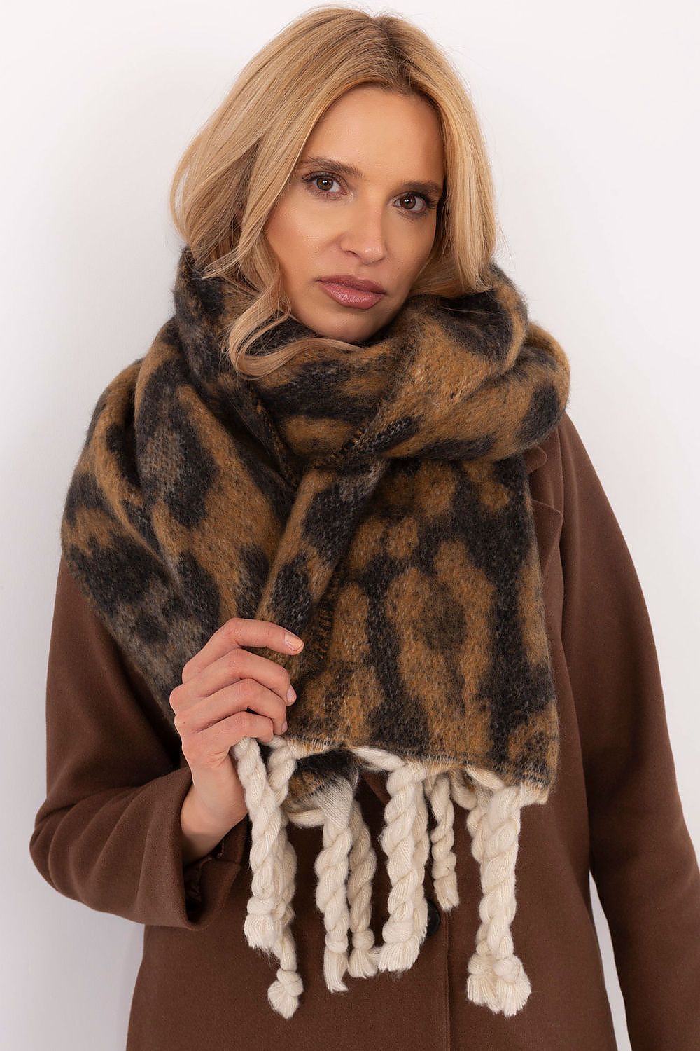 Close-up of an exquisite polyester scarf adorned with an animal motif and stylish fringes, designed by AT for a sophisticated winter look.