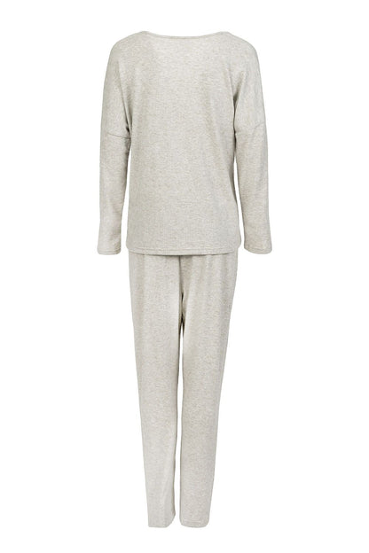 Elegant women's two-piece pajamas set by Momenti Per Me featuring a long sleeve V-neck blouse and slim leg pants, perfect for stylish homewear in sizes S-XXL.