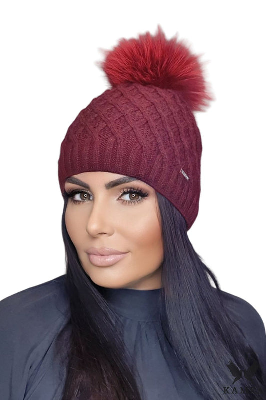 Close-up of a Kamea women's premium burgundy pom-pom hat, highlighting the intricate weave and plush texture of the mohair wool.