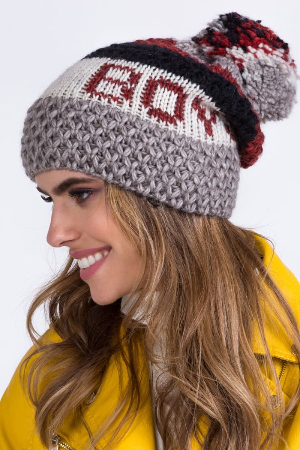 Stylish Kamea women's fuchsia hat displayed elegantly, featuring a large knitted pompom and rich textures, ideal for winter attire.
