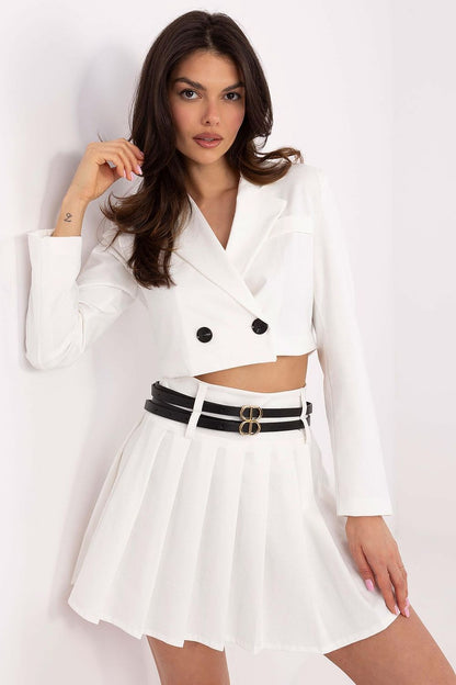 Model wearing Italy Moda pleated mini skirt with chic outfit, demonstrating its versatility for work or formal events, combining elegance with comfort.