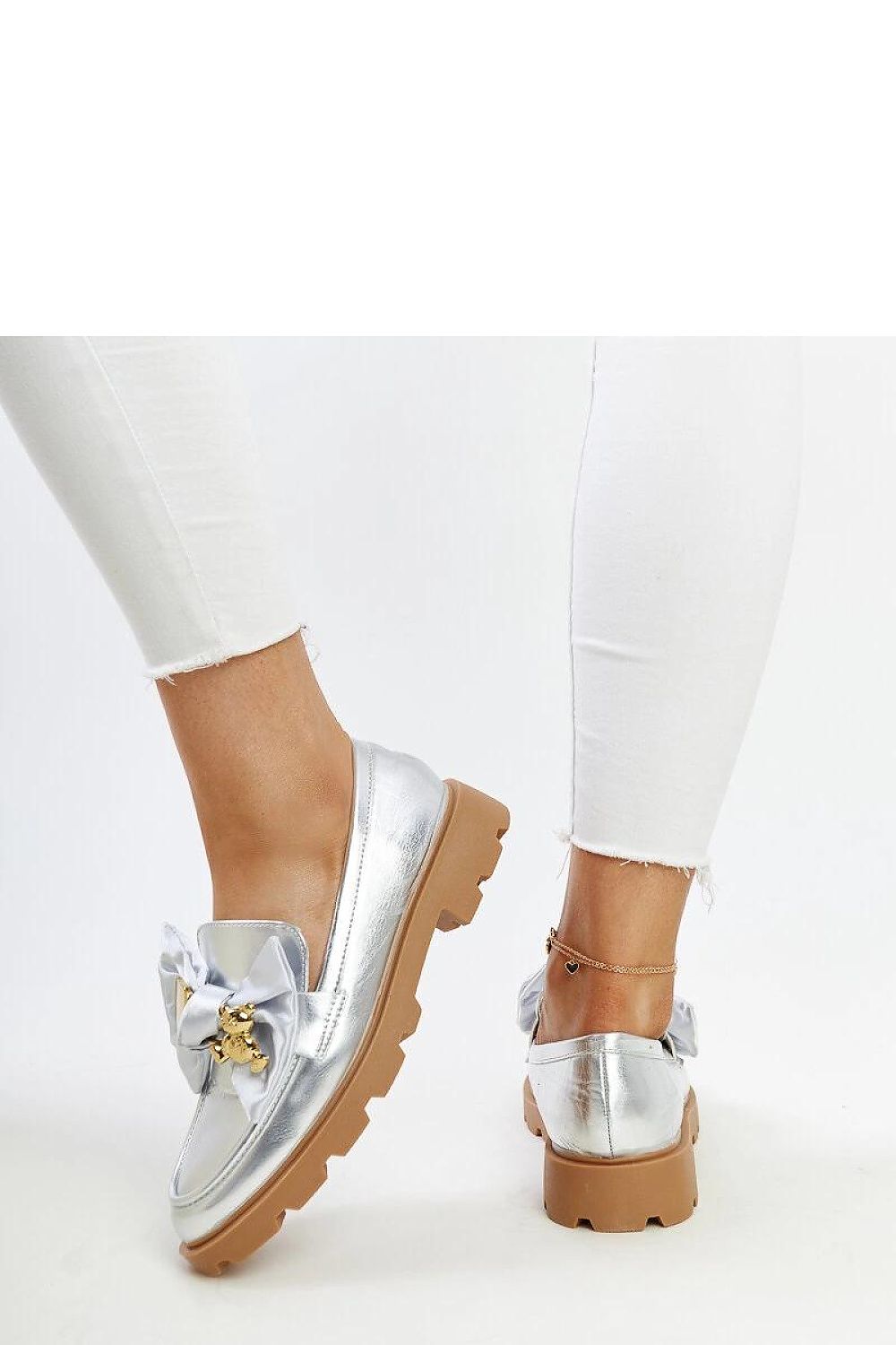 Elegant Solea silver moccasins with a stylish decorative buckle, crafted from high-quality synthetic material, perfect for both casual and formal occasions.