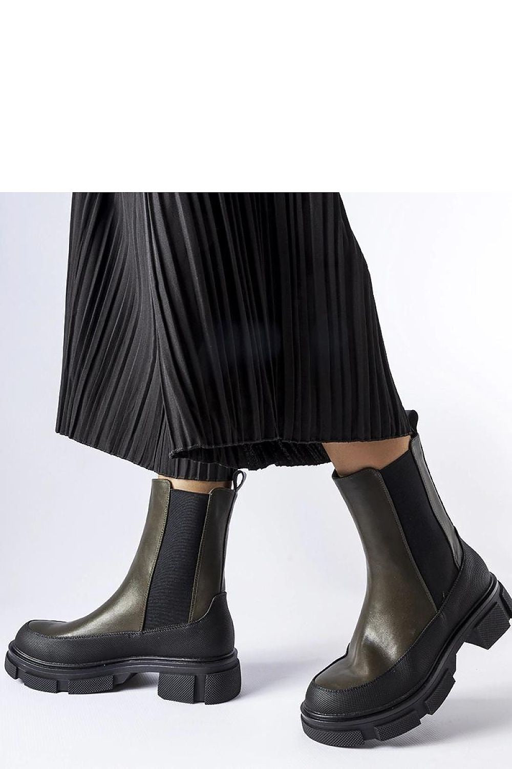 Solea Women's green and black Faisal Slip-On Boots displayed against a luxurious backdrop, highlighting their fashionable design and eco-friendly materials.