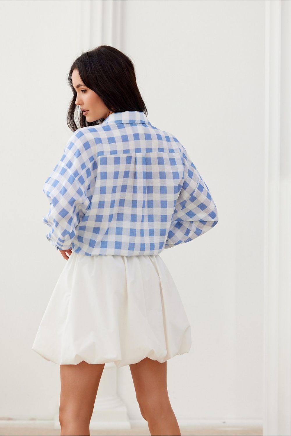 Model wearing Roco Fashion oversized shirt in a chic setting, highlighting the shirt's relaxed fit and stylish design.
