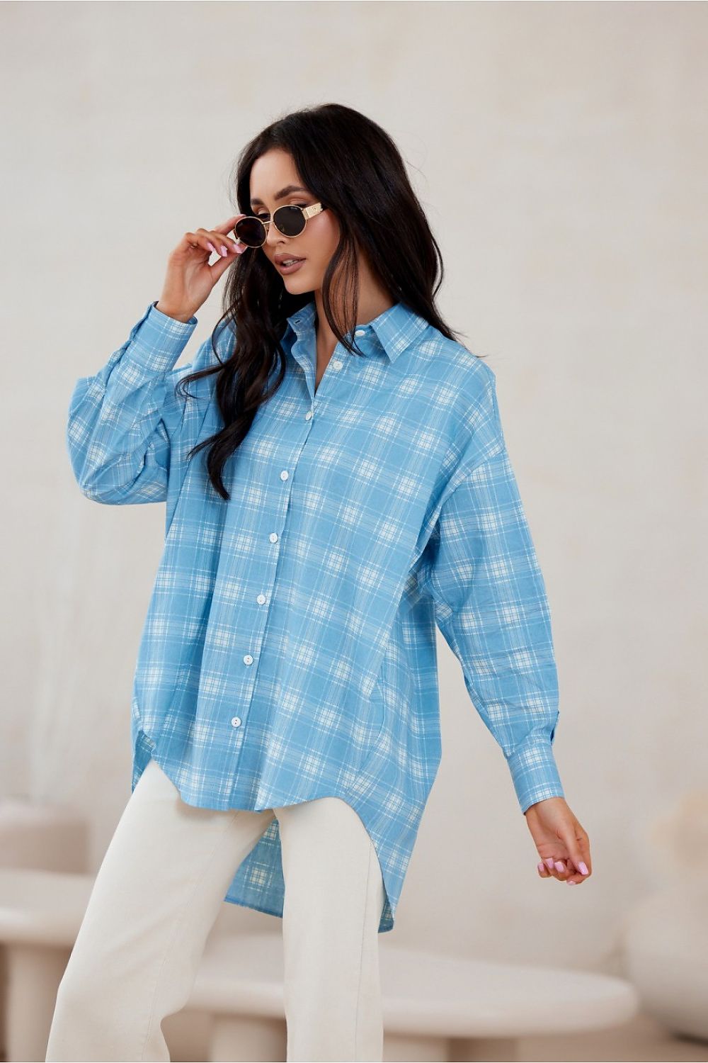 Fashion model wearing Roco Fashion oversized long sleeve shirt with asymmetrical design and buttoned cuffs, epitomising chic elegance.