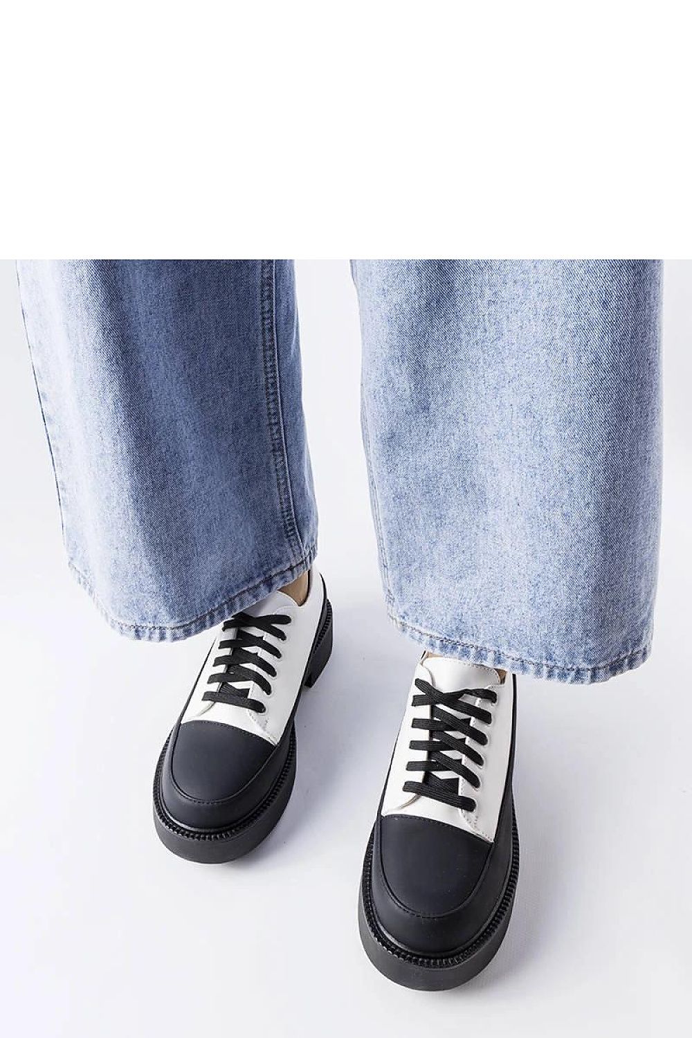 Solea black flat-heeled summer shoes displayed with vibrant floral attire, perfect for elevated summer fashion.