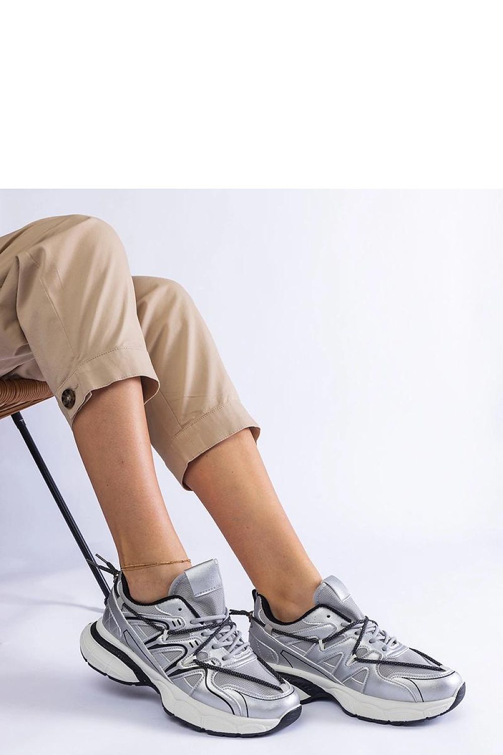 Close-up of Solea's silver women's sneakers with a laced closure, showcasing the high-quality synthetic leather and sporty black rubber sole.