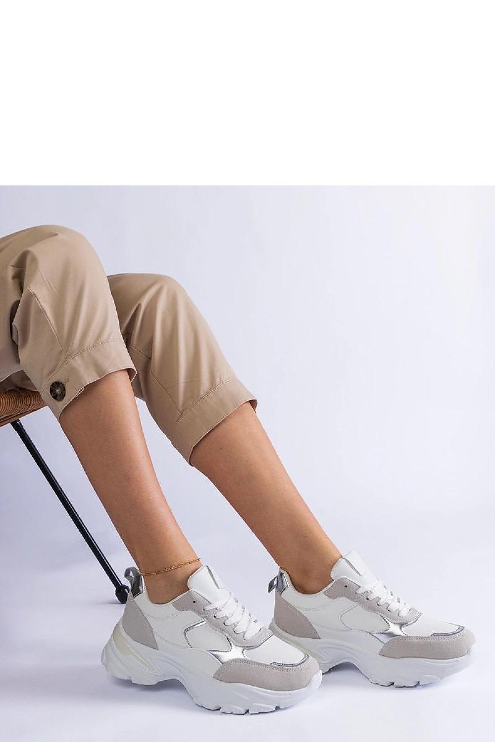 Close-up view of Solea's sleek white sneakers, highlighting the durable Torreza Hurtado rubber sole and stylish low-profile design.