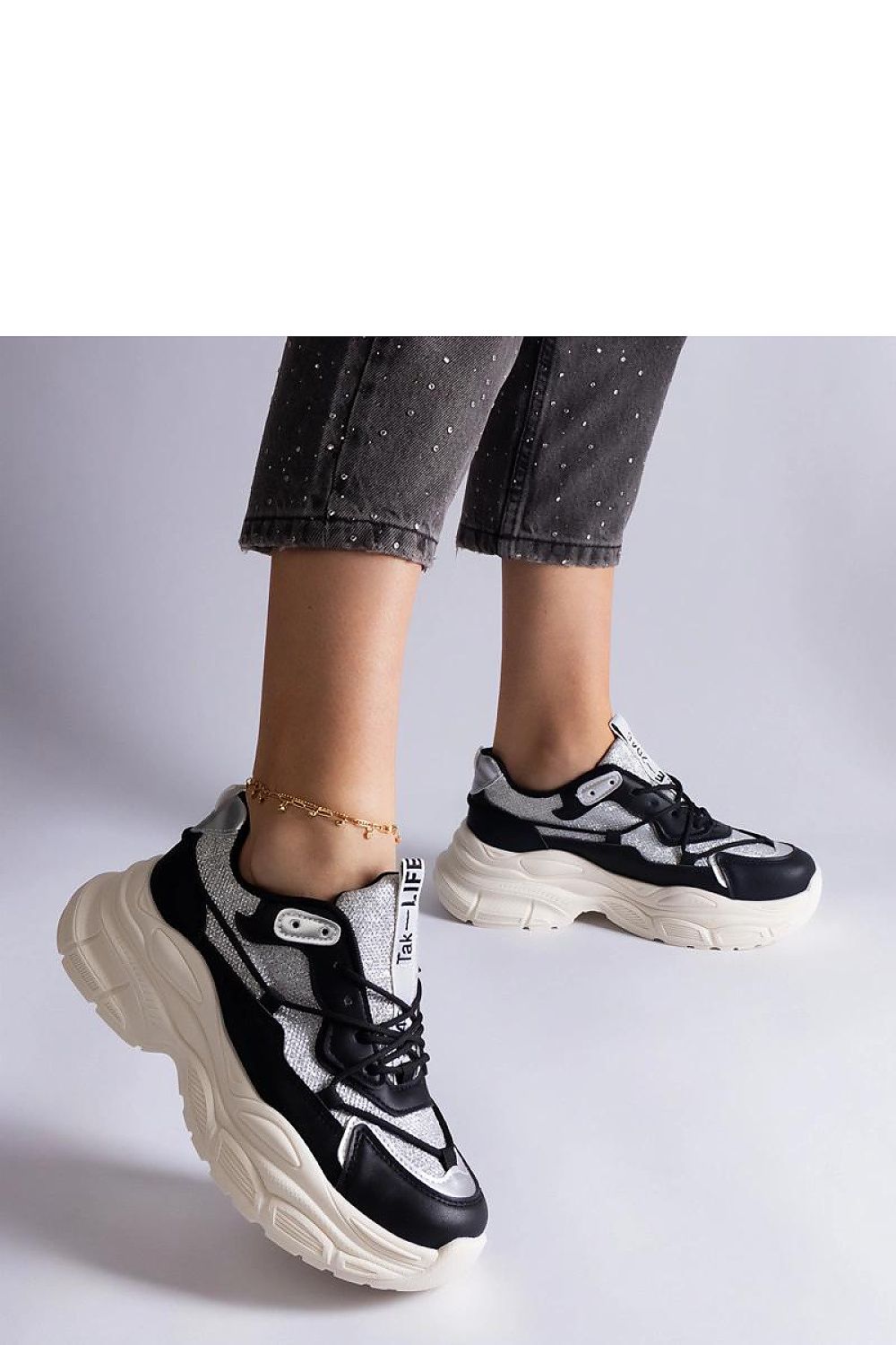 Close-up of Solea black sneakers with brocade detailing, highlighting the high-quality faux leather and stylish lace-up design.