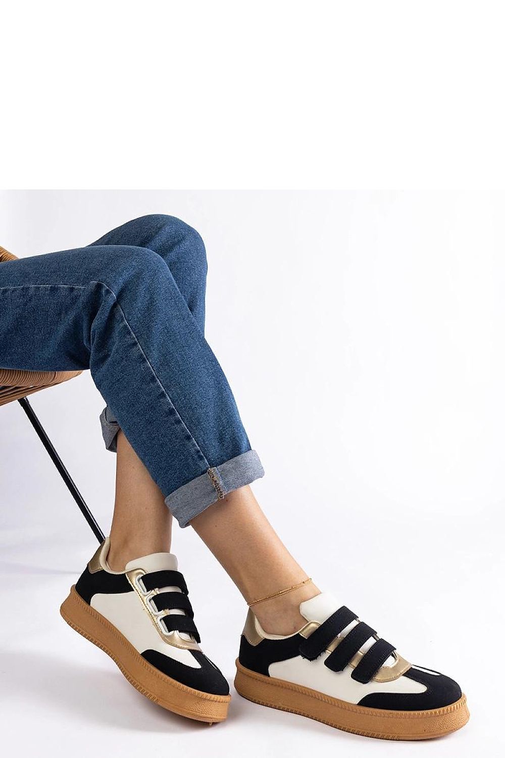 Solea golden sneakers laid flat, with brown rubber soles for stability, ideal for fashion-forward individuals seeking comfort.