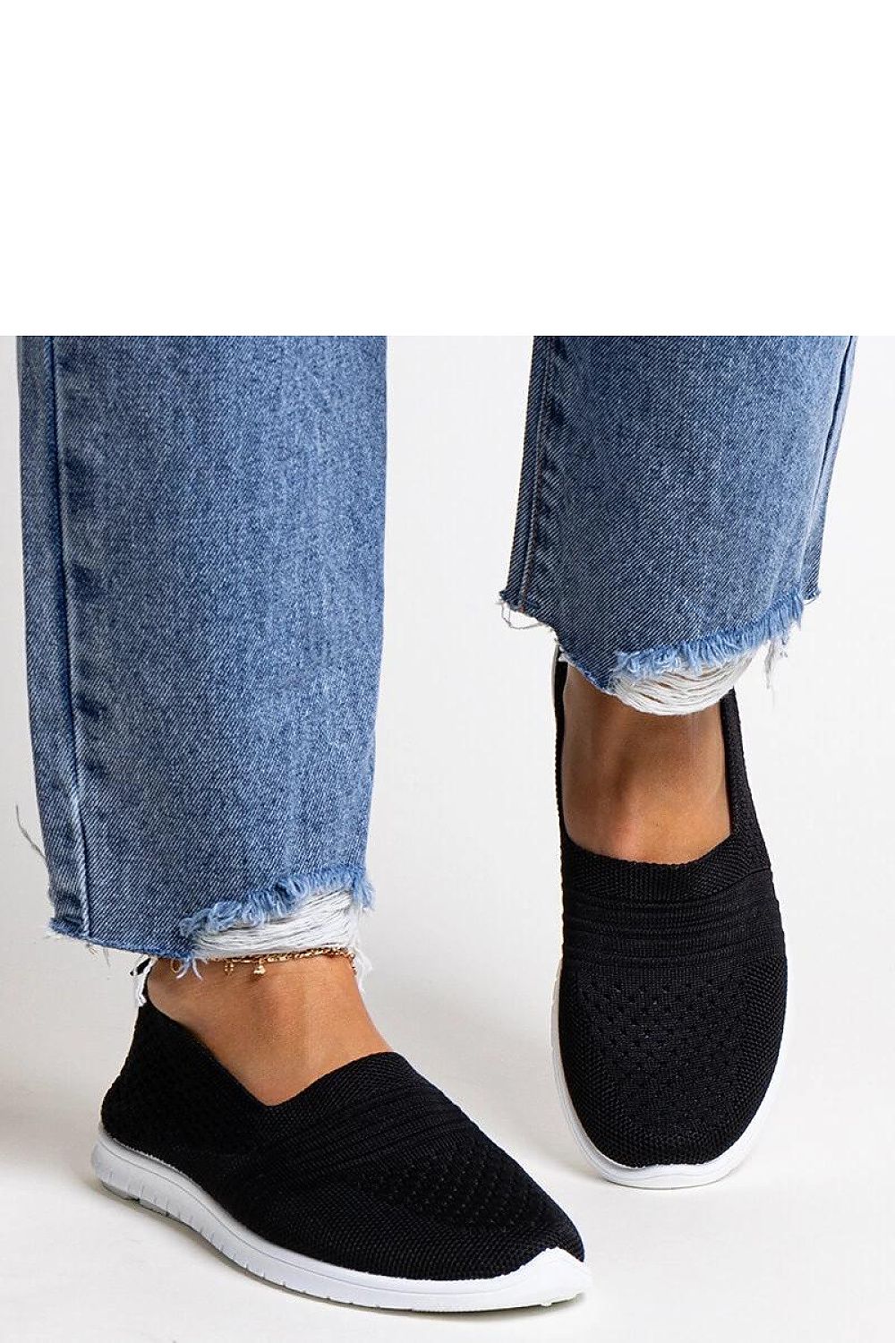 Dynamic shot of Solea black slip-on sneakers for women, featuring a durable white rubber sole, perfect for effortless chic on the go.