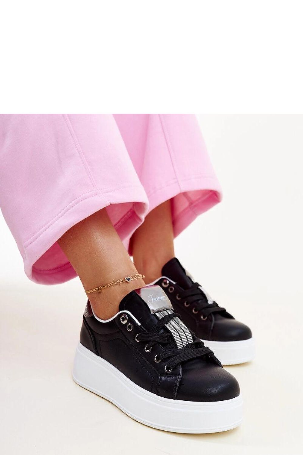 Stylish Solea black sneakers featuring a white rubber sole and a modern low cut design, accented with Maurizia zirconia for a touch of luxury.