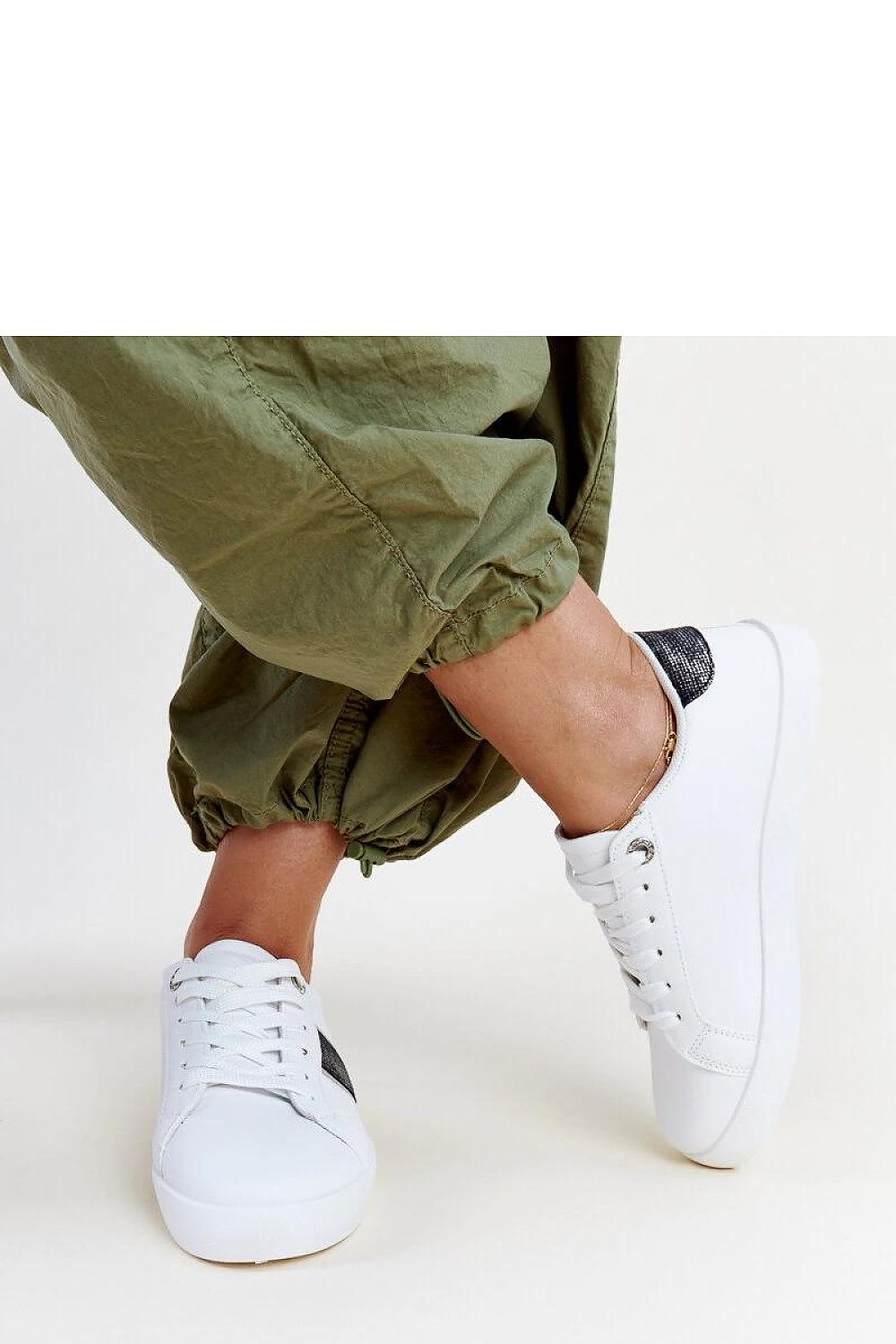 Elegant Solea white and gold sneakers for women featuring a stylish low design with decorative strap and stunning zircons, perfect for fashionable outings.