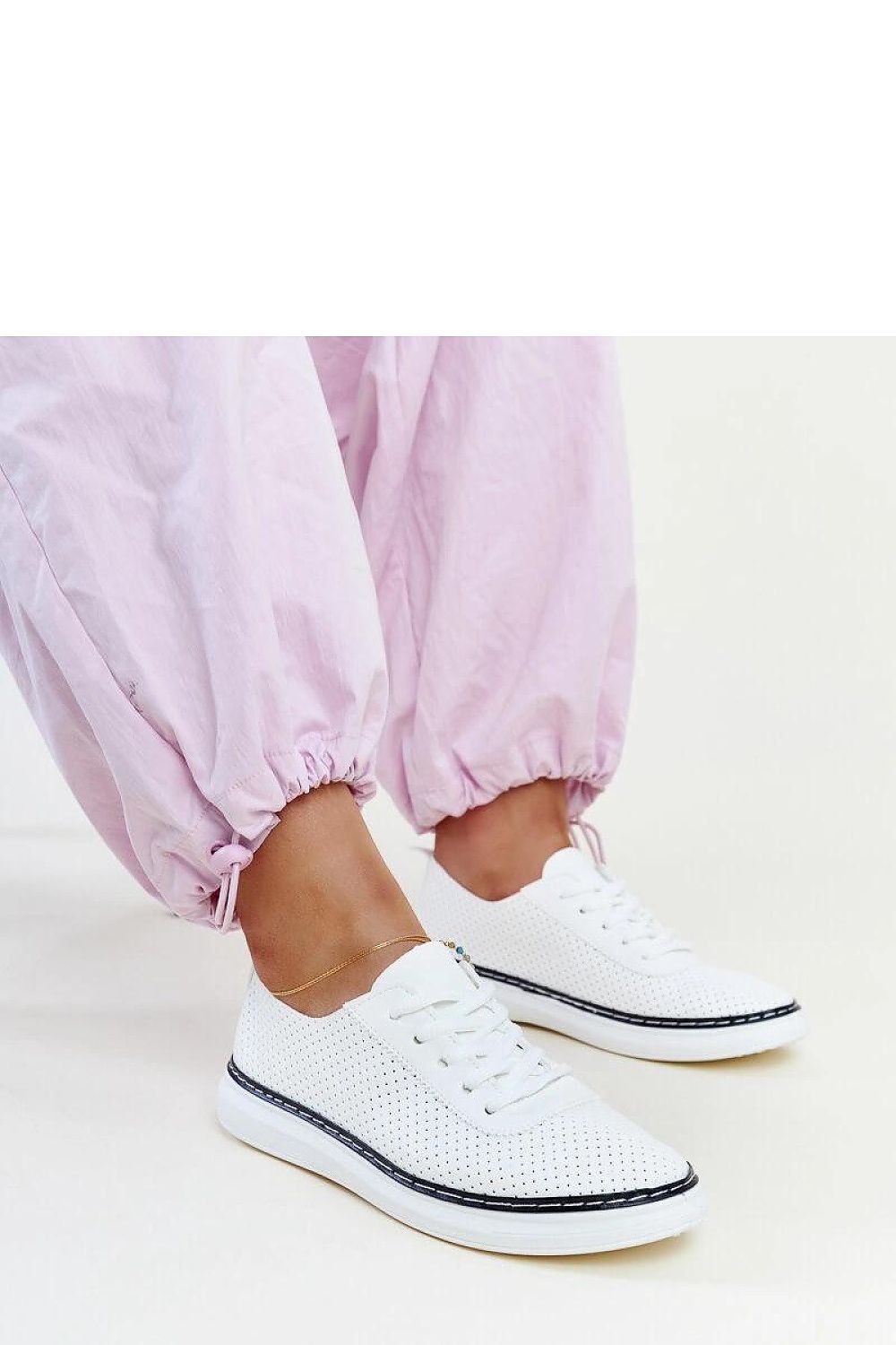 Solea Biserka eco leather sneakers displayed on a minimalist background, showcasing their trendy perforated design and comfortable fit.