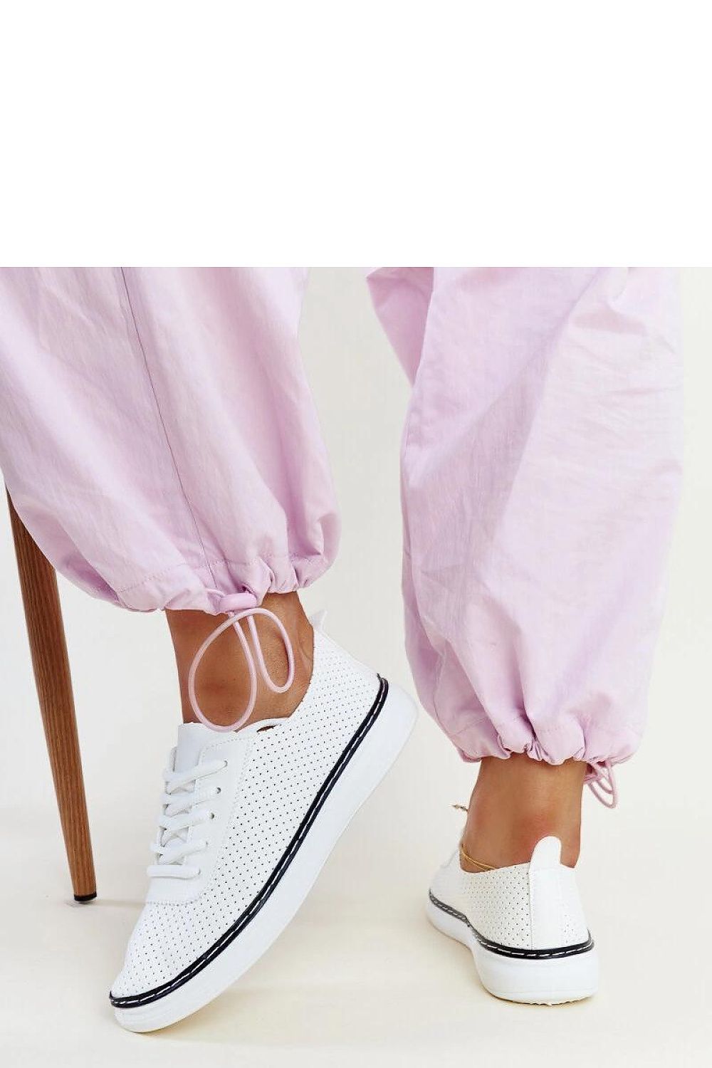 Elegant white and grey Biserka sneakers by Solea, showcasing a trendy perforated pattern suitable for sporty activities.