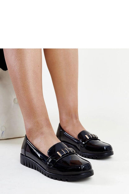 Solea stylish black patent loafers featuring a decorative strap, showcasing luxury women's footwear.