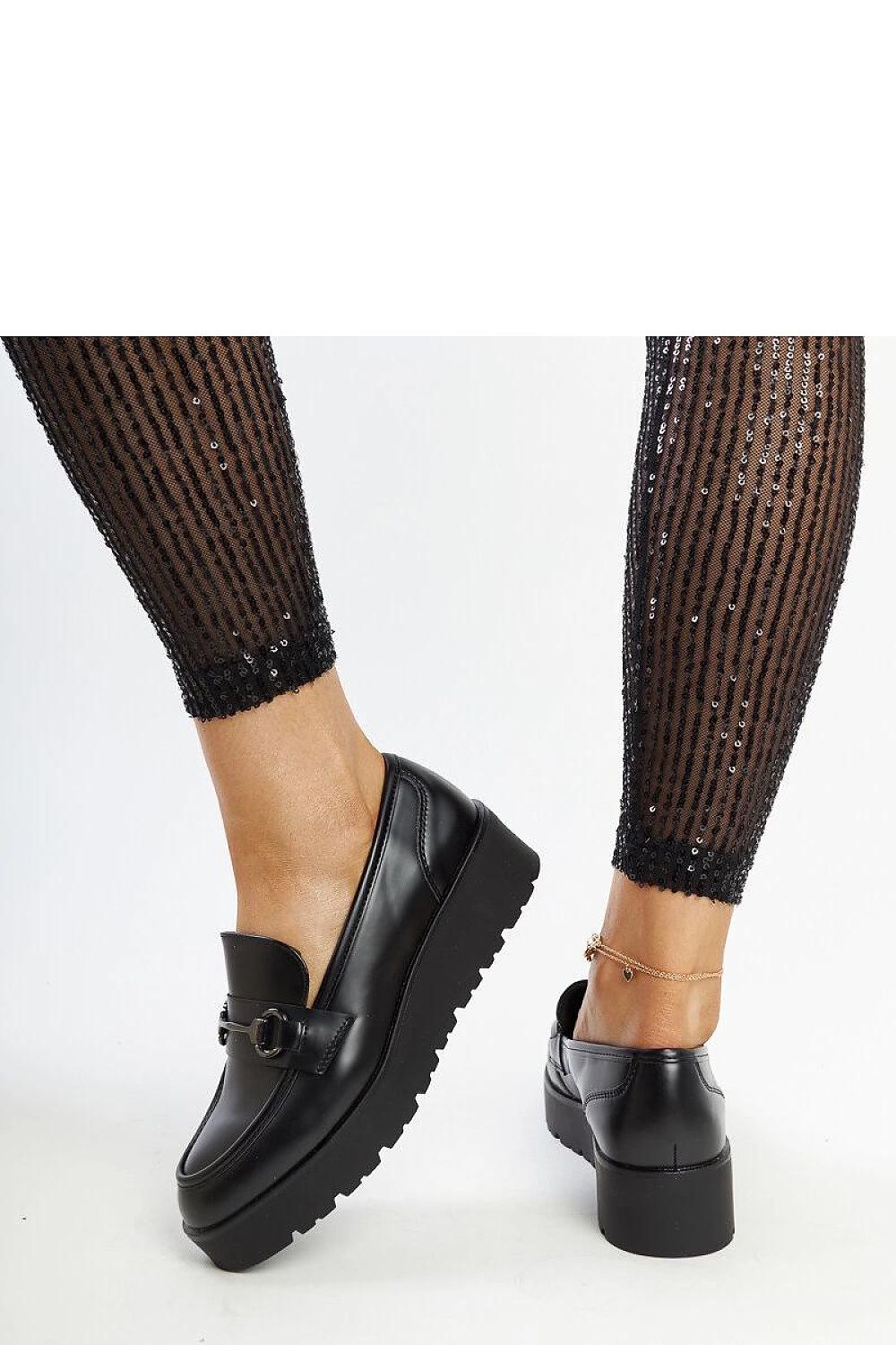 Close-up of Solea's women's black wedge moccasins with a medium rubber wedge providing comfort and stability, highlighting the luxurious eco leather texture and refined craftsmanship.