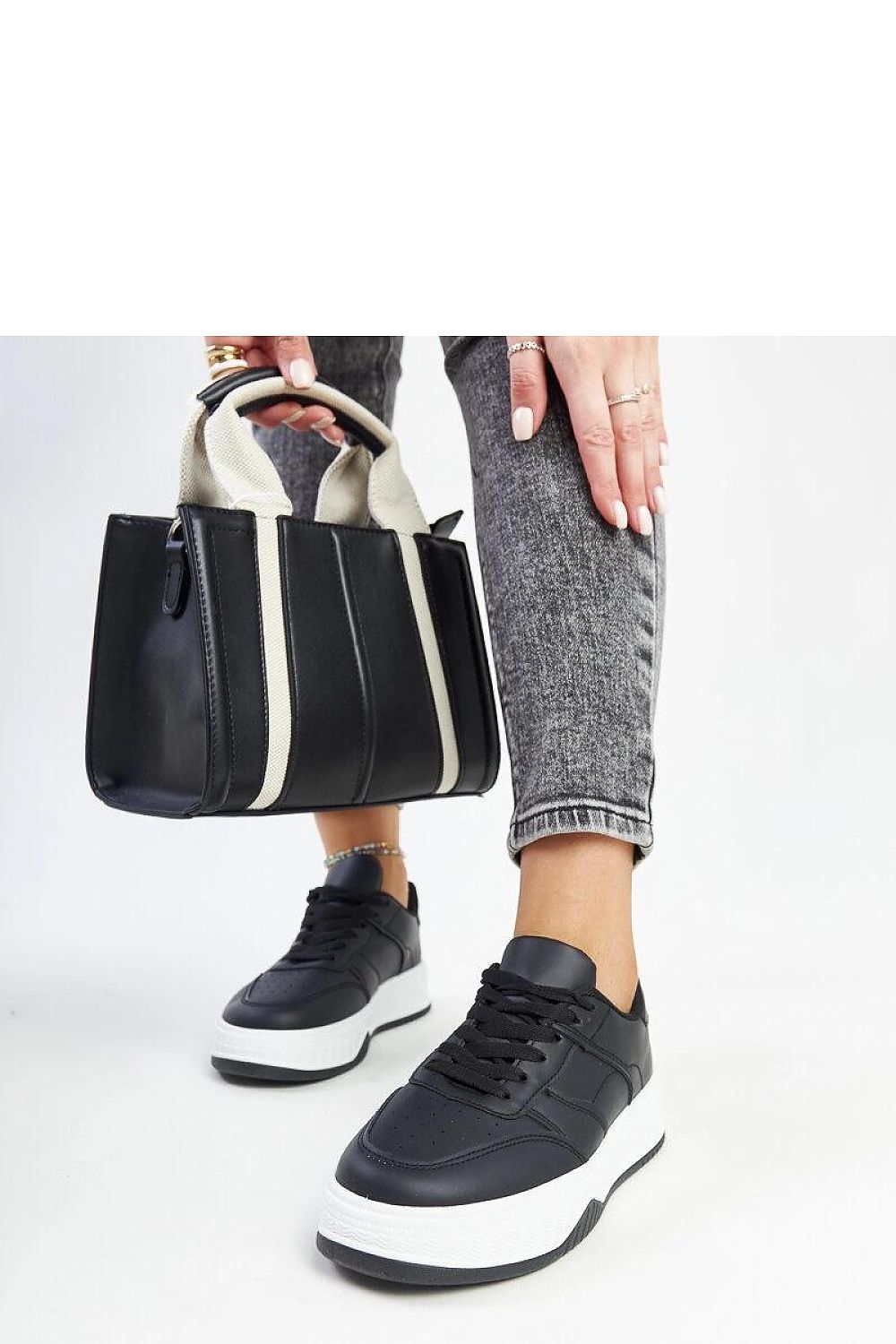 Solea black sneakers featuring a sleek design with thick rubber sole, showcasing luxurious faux leather craftsmanship and stylish lace-up closure.