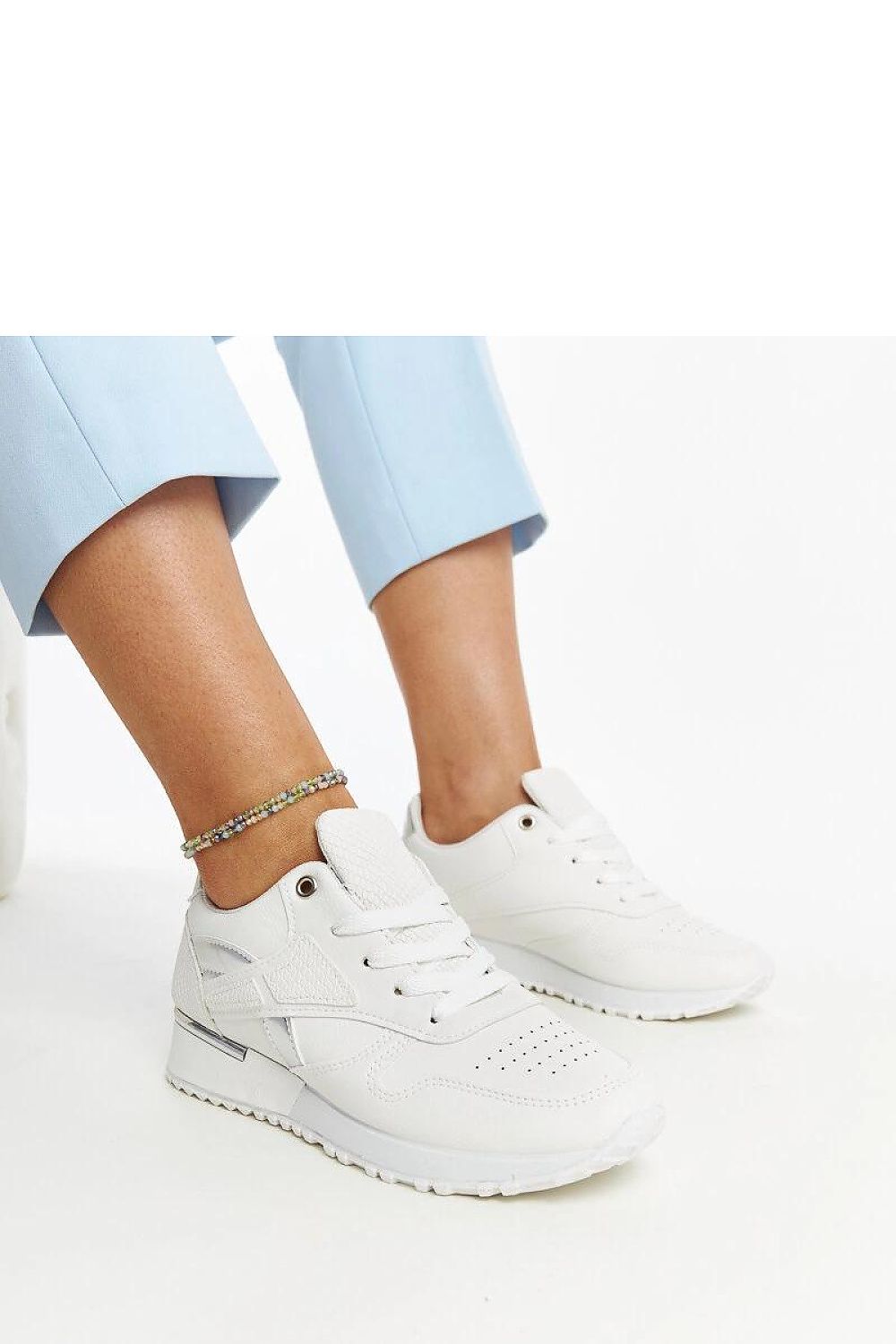 Close-up of Solea's fashionable white sneakers with unique snake skin design, perfect for a standout look.