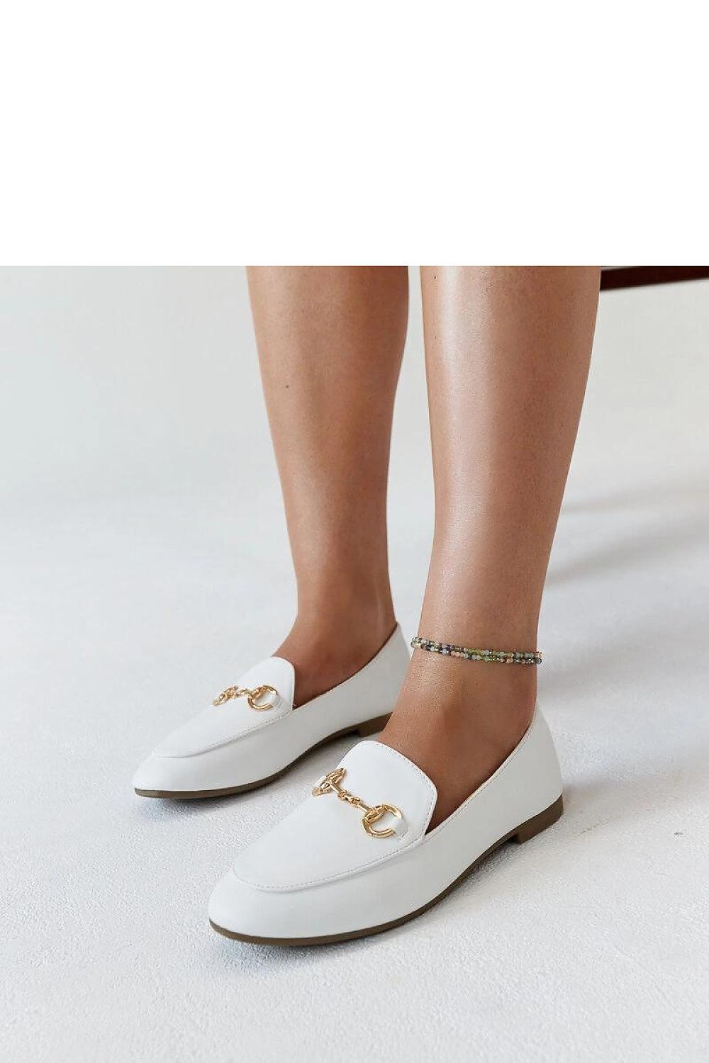 Artistic view of Solea Erminia loafers in beige eco-leather, emphasizing the fashionable buckle and lightweight construction, perfect for pairing with summer attire.