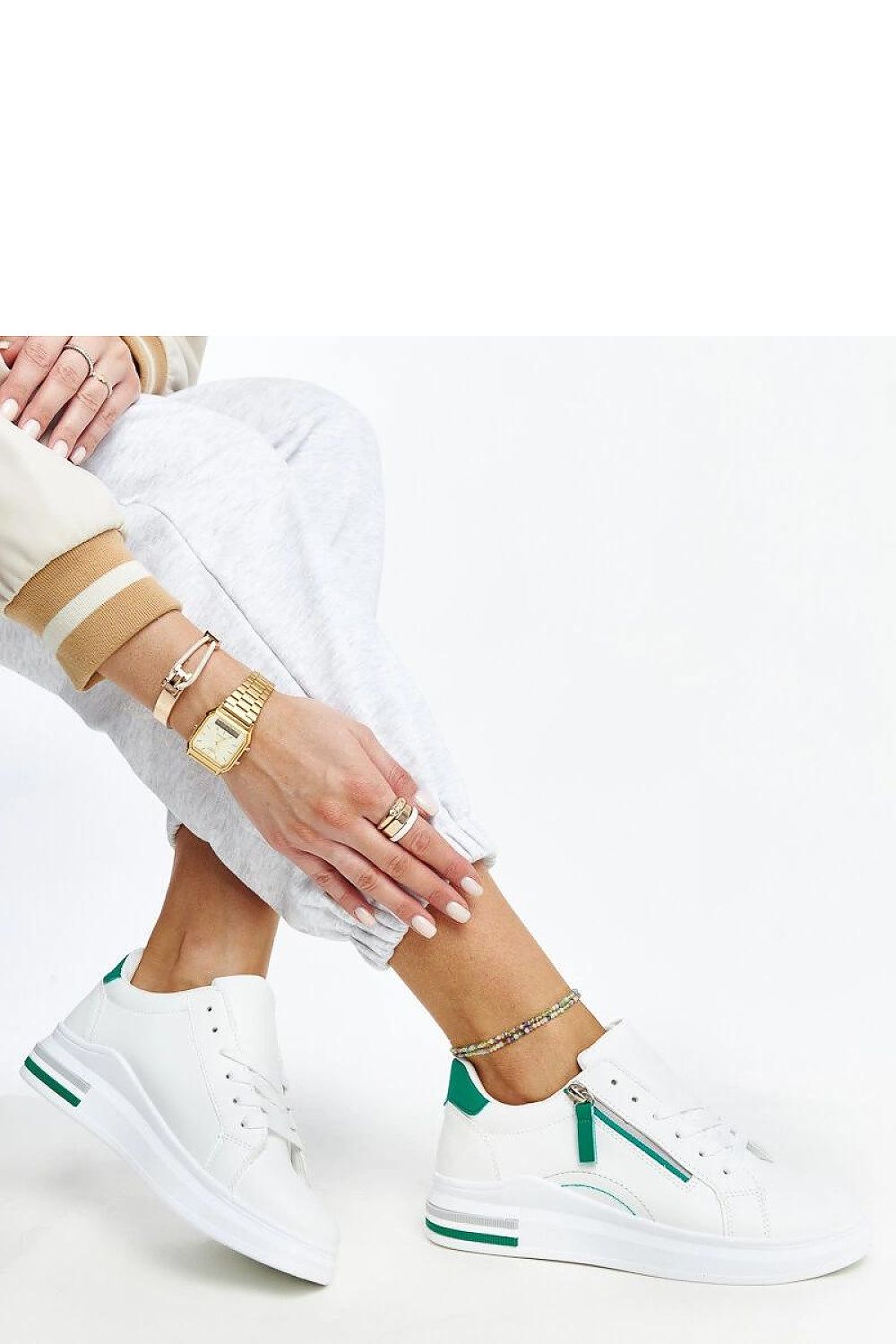 Close-up view of Solea's white sneakers showcasing the eco-friendly zam leather material and elegant green inserts.