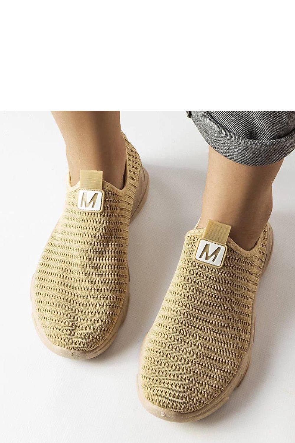 Stylish Solea women's slip-on sports shoes in dark beige set against a minimalist backdrop, emphasizing their versatile appeal for active women.