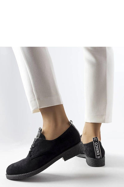 Model wearing Solea Eco-Suede Sneakers in chic black, paired with fashionable attire for a sophisticated look, available in US Sizes 5.5-10.5.