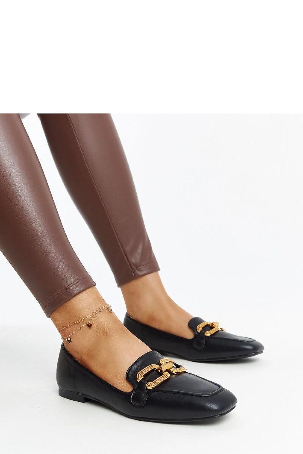 Close-up view of Solea's black eco leather moccasins with a decorative buckle, perfect for chic summer ensembles.