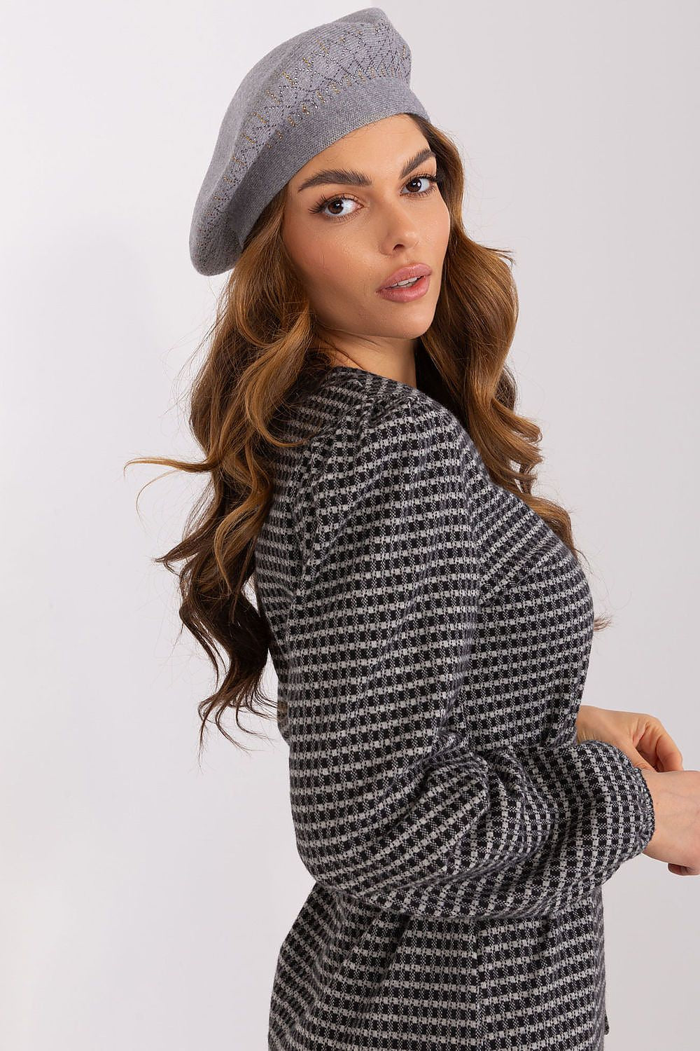 Fashion model wearing an elegant shiny beret hat from AT, paired with a chic outfit for a stylish look perfect for any occasion.