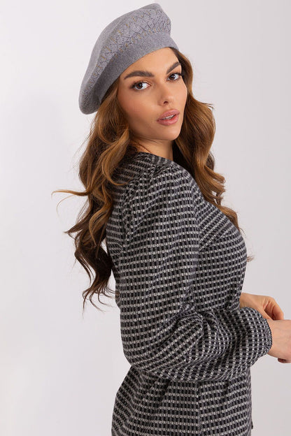Fashion model wearing an elegant shiny beret hat from AT, paired with a chic outfit for a stylish look perfect for any occasion.