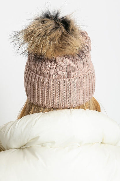 Elegant winter hat designed by AT with a stylish wide cuff and soft fluffy pompom, ideal for cold weather, made with a luxurious mixture of acrylic, cotton, and cashmere.