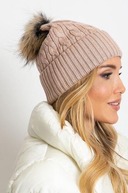 Chic winter beanie by AT showcasing a fashionable wide cuff and fluffy pompom, composed of 50% acrylic, 30% cotton, and 20% cashmere, perfect for sophisticated style.