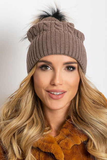 Elegant winter hat from AT, designed with a stylish wide cuff and soft fluffy pompom, made of high-quality materials including acrylic, cotton, and cashmere.