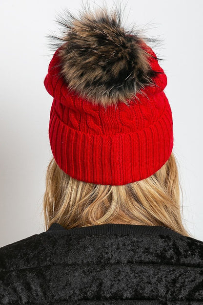 Stylish luxury winter cap by AT featuring a wide cuff and fluffy pompom, crafted from a high-quality mix of acrylic, cotton, and cashmere for elegance and comfort.