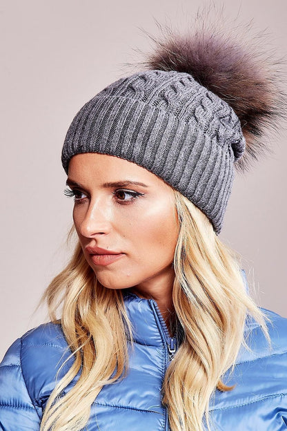 Chic winter cap by AT showcasing a luxurious fluffy pompom and wide cuff design, composed of high-quality materials: 50% acrylic, 30% cotton, and 20% cashmere.