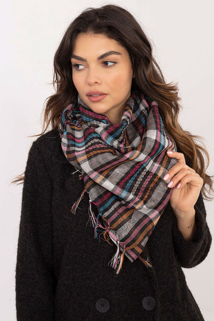 AT's fashionable checkered neckerchief scarf in a chic setting, highlighting its warm, soft texture and decorative fringes.