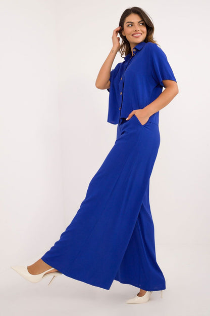 Model showcasing the Lakerta Viscose Set with high waist trousers and classic cut shirt in a sophisticated environment.