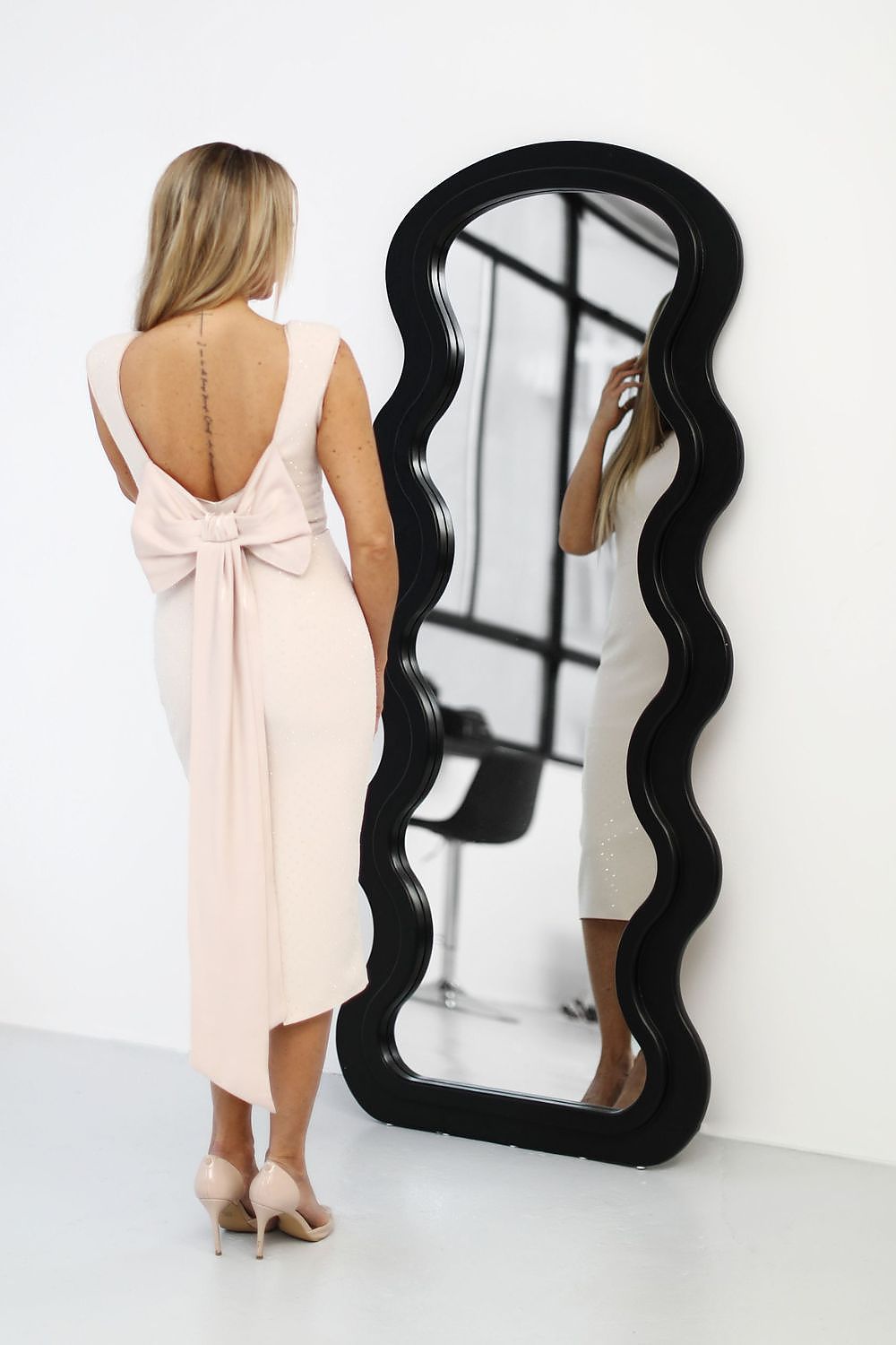 Detail view of the exquisite beige cocktail dress by Jersa, showcasing the luxurious fabric and romantic bow embellishment.