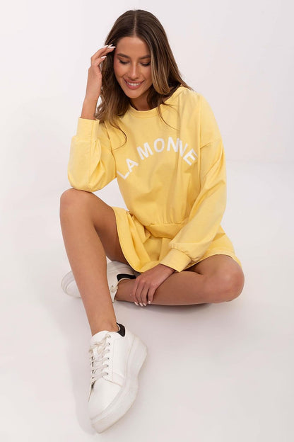 Luxurious Italy Moda sweatshirt featuring long sleeves and round neckline, perfect for sophisticated everyday wear paired with a pleated mini skirt.