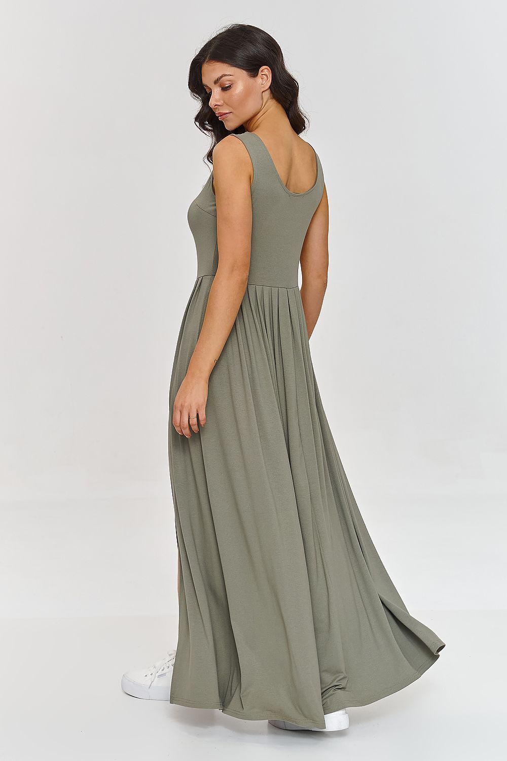 Model in Makadamia elegant maxi dress featuring a deep neckline and wide straps, illustrating feminine elegance and sophistication.