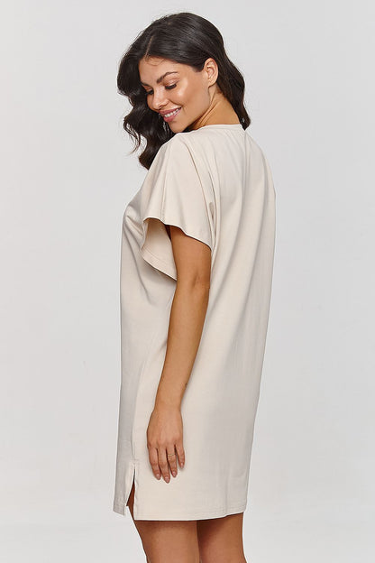 Elegant Makadamia cotton mini dress for women in bright sunlight, showcasing a loose fit and round neckline, perfect for summer outings.