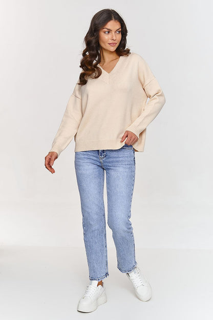 Makadamia's Elegant V-Neck Sweater styled with elegant trousers, perfect for versatile day-to-night fashion.