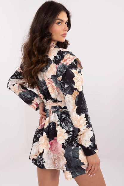 Elegant women's mini jumpsuit with floral print by Italy Moda, featuring ruffled shoulders and long sleeves, perfect for formal occasions.
