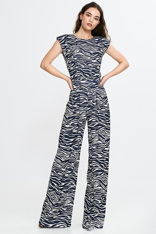 Elegant women's jumpsuit by Nife featuring a sophisticated boat neckline and stylish shoulder pads, designed for sizes EU 36-42.
