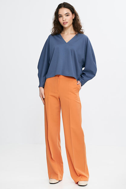 Stylish Nife oversized V-neck blouse displayed on a model, highlighting its flattering fit and sophisticated look, perfect for pairing with high-waisted bottoms.