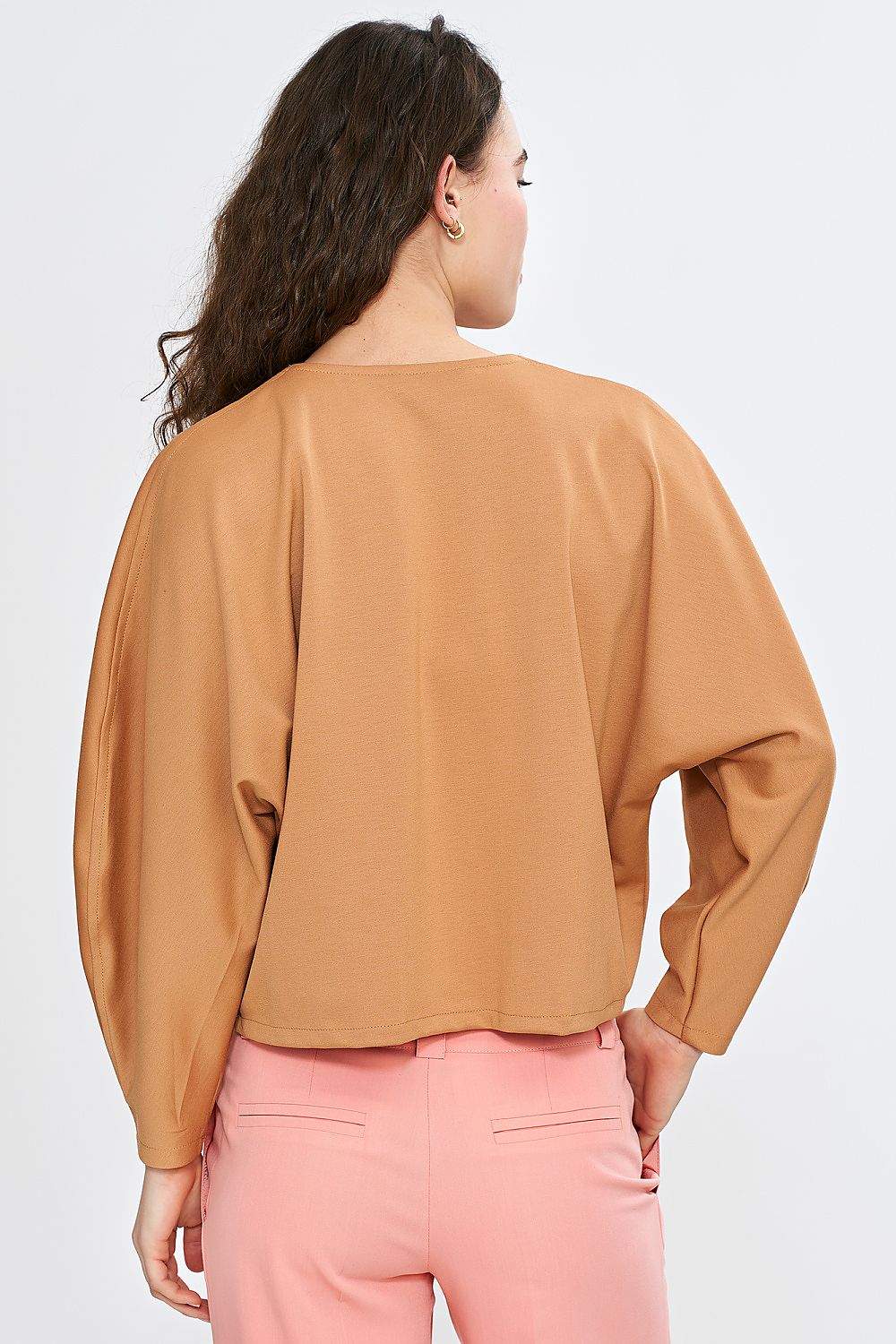 Nife oversized V-neck blouse styled with high-waisted trousers, demonstrating its flattering fit and sophisticated design for chic outfits.