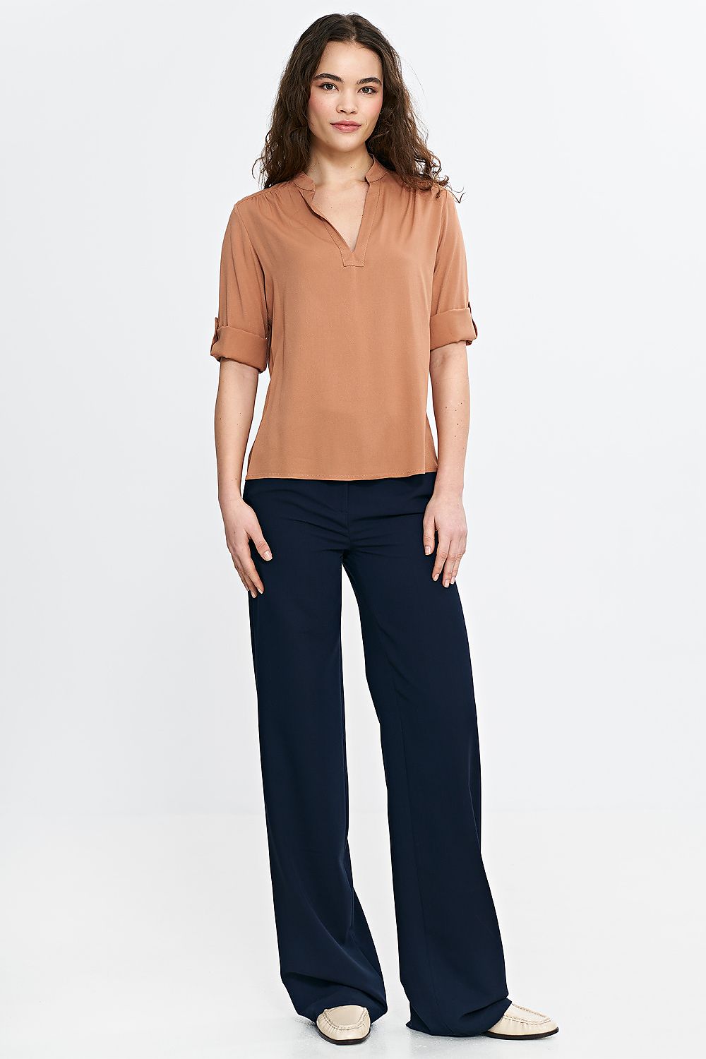 Detailed close-up of Nife's lightweight viscose blouse, featuring delicate pleats at the collar and adjustable sleeves, perfect for elegant styling.