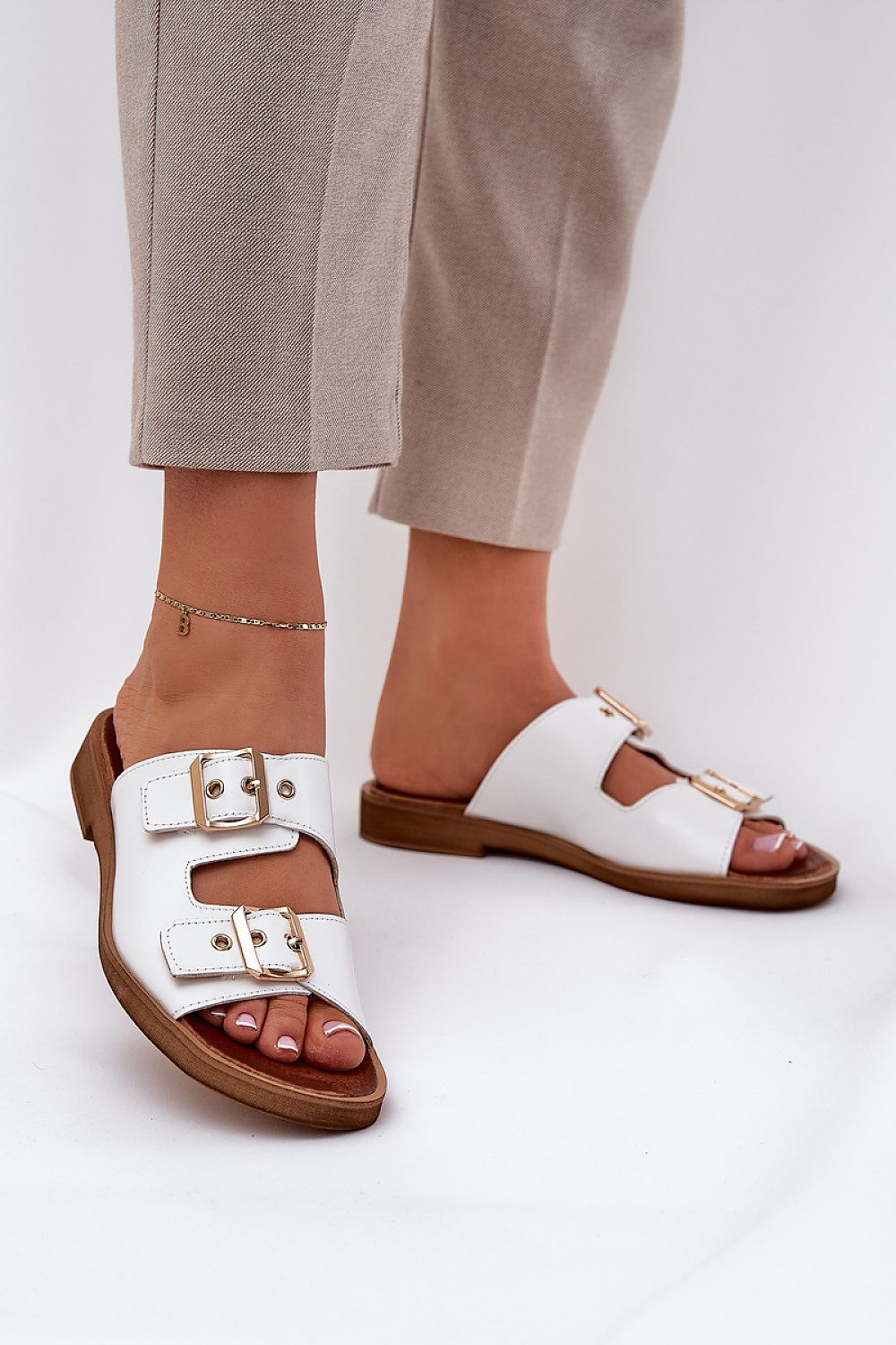 Luxury women's leather slides with flat heel and adjustable gold buckles by Step in style, designed for comfort and sophistication.