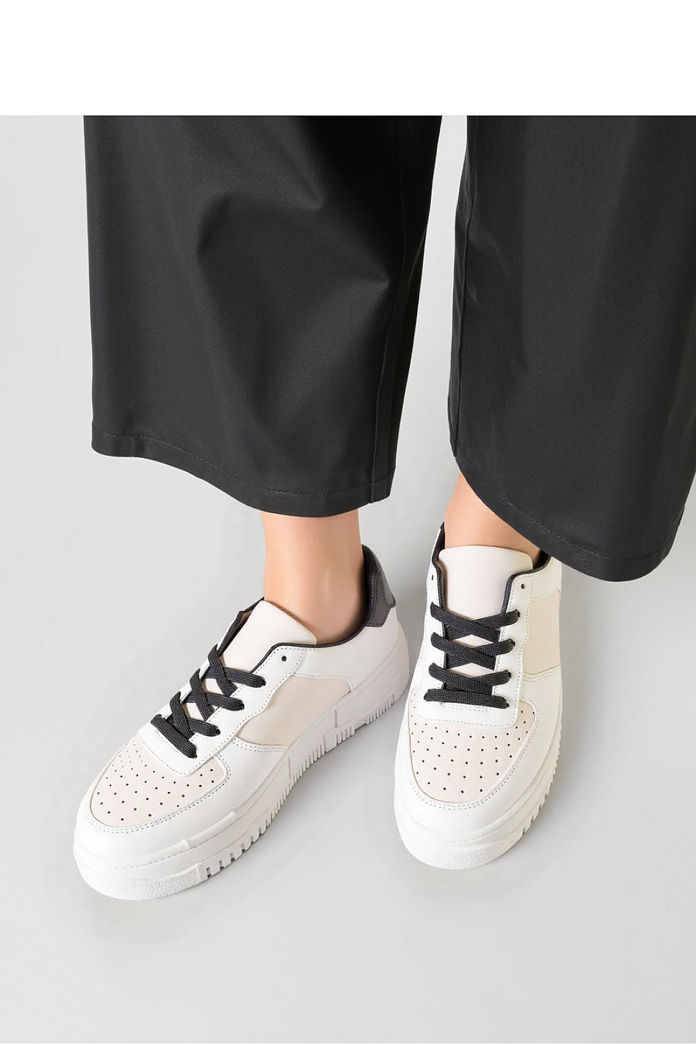 VEXANA beige perforated sneakers elegantly styled against a chic urban backdrop, complemented with thick sturdy soles for comfort, by Inello.