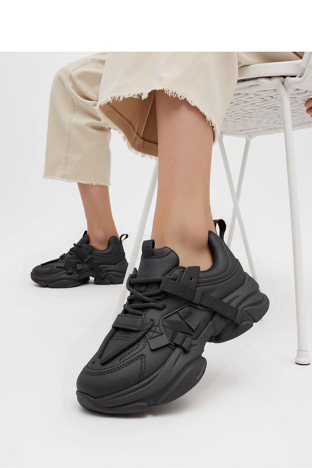 Close-up of Titan Black Sneakers by Inello showcasing unique strap details and minimalist black design for a modern high-fashion look.